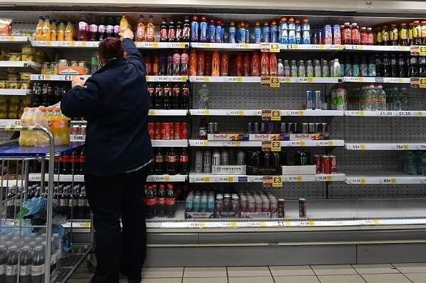 A TESCO WORKER STAKING SHEELS AT The MEAL DEAL SECTION