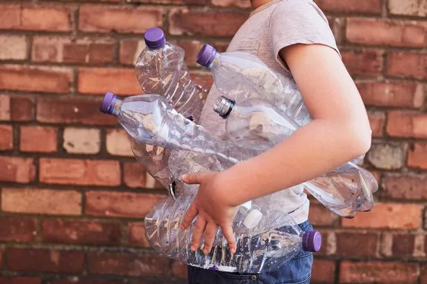Young Boy HOLDING PLASTIC BOTTLE FOR RECYCLING