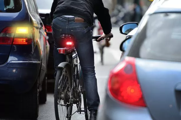 Male Bicyclist in Heavy Traffic