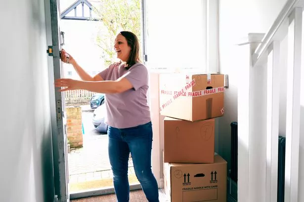 Woman Entering New House with Boxes