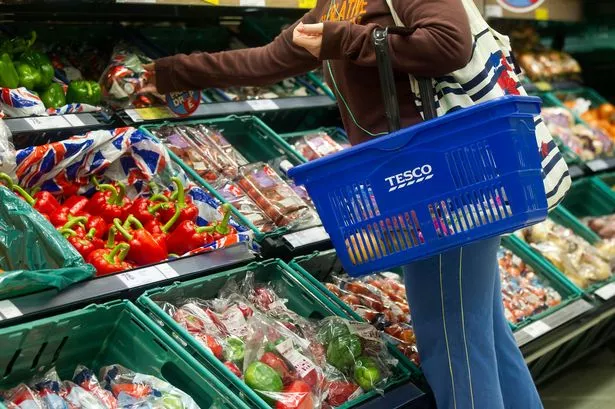 A Customer Browses the Fruit and Vegetable Aisle in A Tesco Store