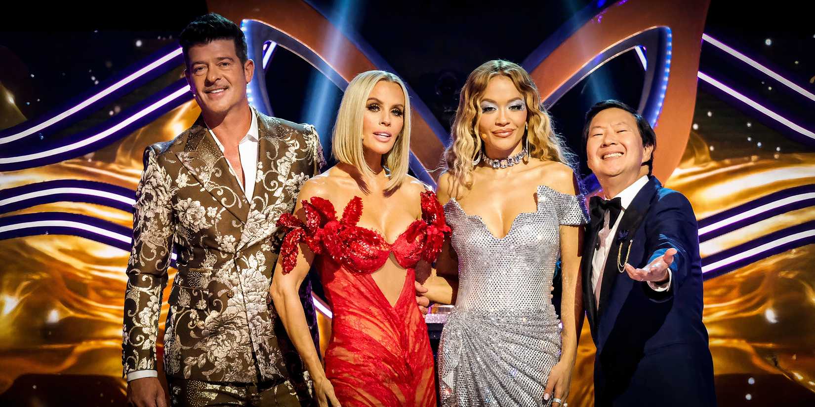 The masked Singer Panelists Robin Thicke, Jenny McCarthy Wahlberg, Rita Ora, and Ken Jeong Dressed up in Fancy Clothes