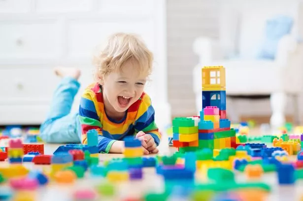 Child Playing With Colorful Toy Blocks