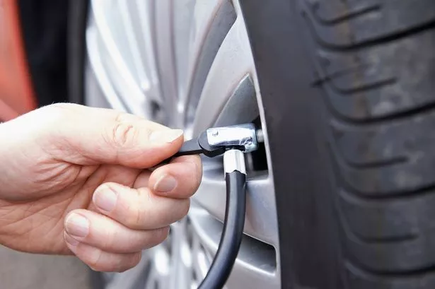 Close Up of Man Inflating their Car with Air Pressure Line
