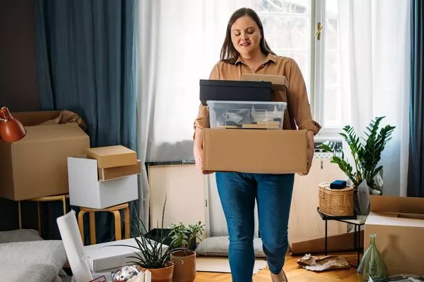 Young happy woman carrying boxes with personal belongings
