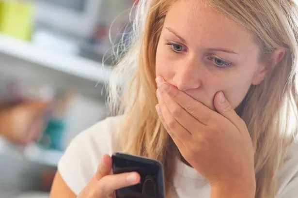 A Woman Looking Shocked AT A Phone