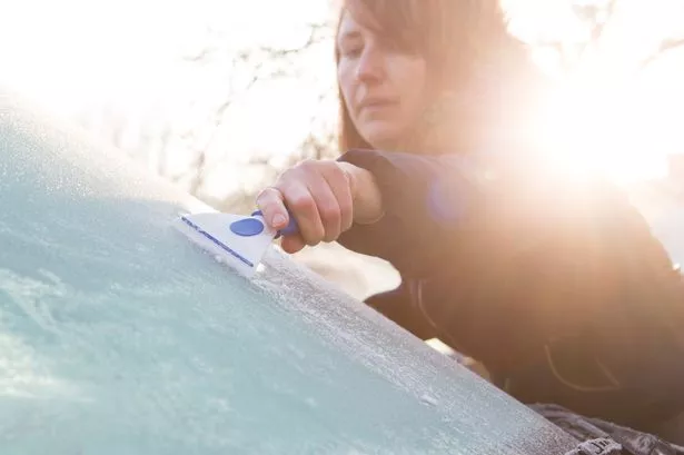 Image of Woman Scraping Ice from Windscreen Car