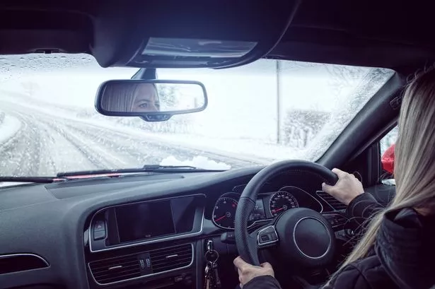 Woman Driving Car in the UK in Winter Snow