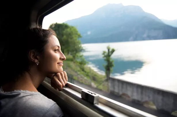 Smiling woman looking at the view from the train