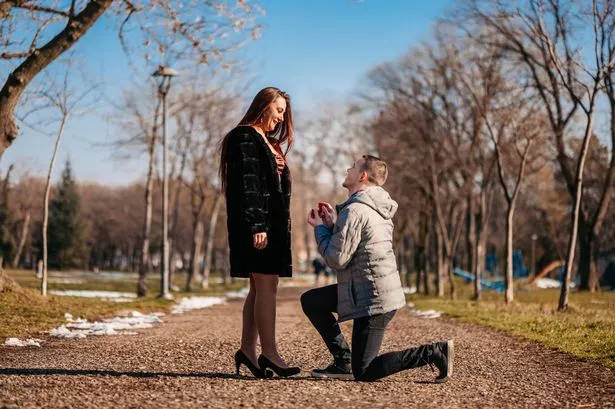 Man proposing to his beautiful girlfriend in the park