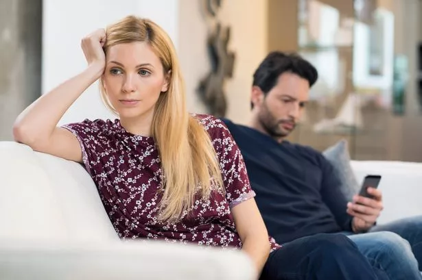 Woman Looking UPSet while Her Male Partner Texts on His Phone