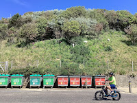 Photo by Sheila Webber of Colourful Rubbish Bins and Someone on a Bike Going Past in Bournemouth in June 2024
