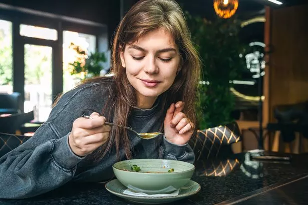 Woman eating vegetable soup in a cafe