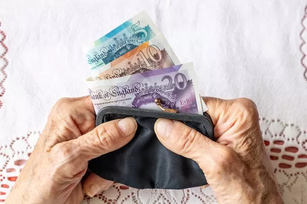 Pensioner holding cash in a purse